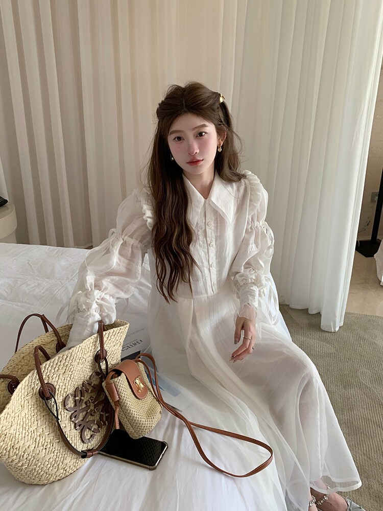 White sheer long-sleeve dress worn by a model indoors