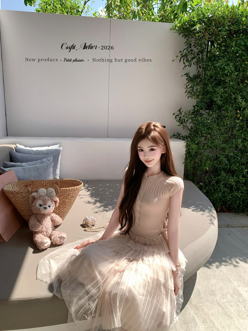 Woman wearing a beige tulle dress seated outdoors in sunlight