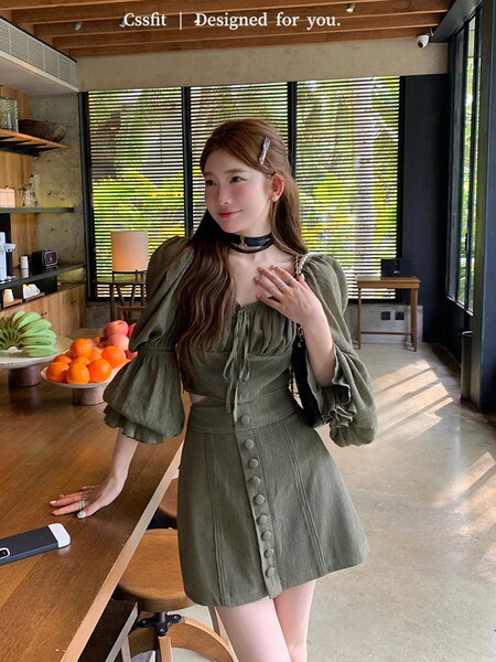 Olive green long-sleeve mini dress worn by a model