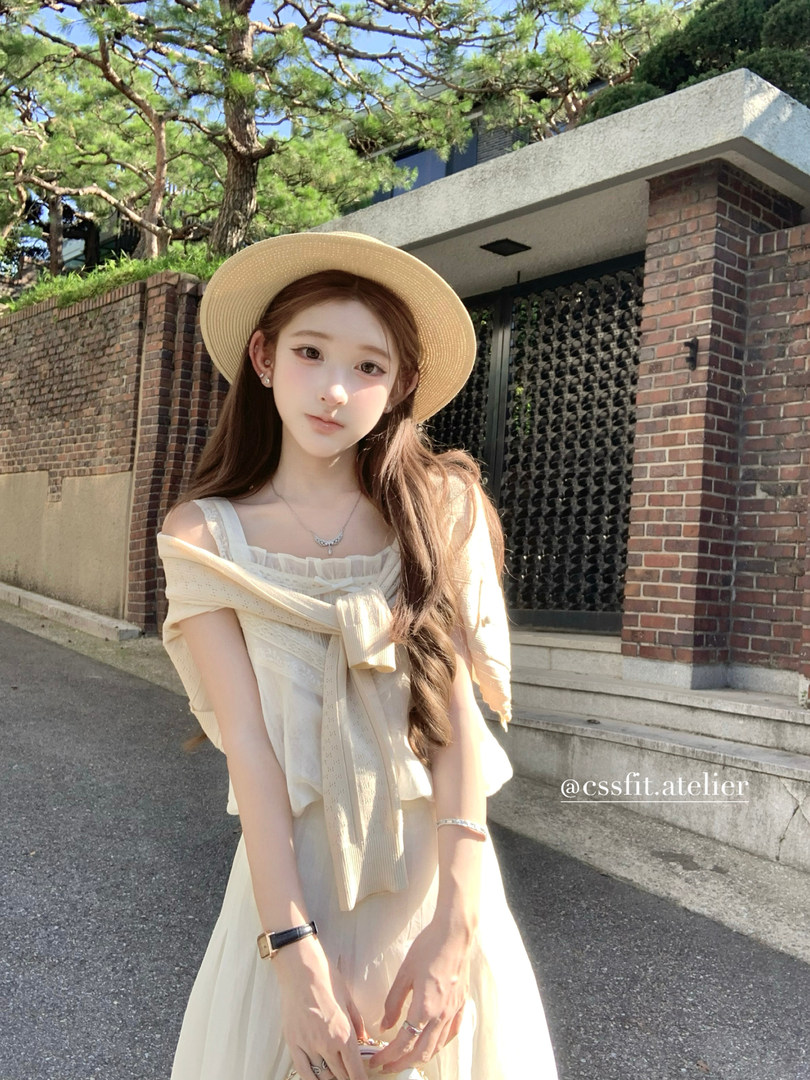 Cream summer dress worn with a straw hat outdoors