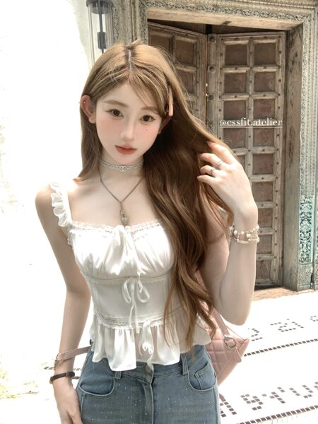 Woman wearing a white ruffled sleeveless lace camisole top