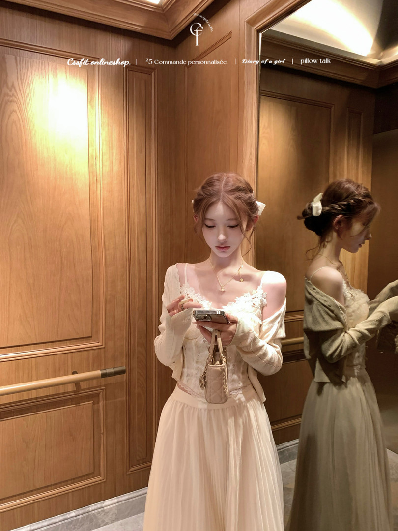 Woman wearing a light cream lace dress with cardigan in a mirror selfie