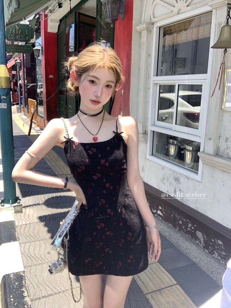 Model wearing a black floral spaghetti-strap mini dress outdoors