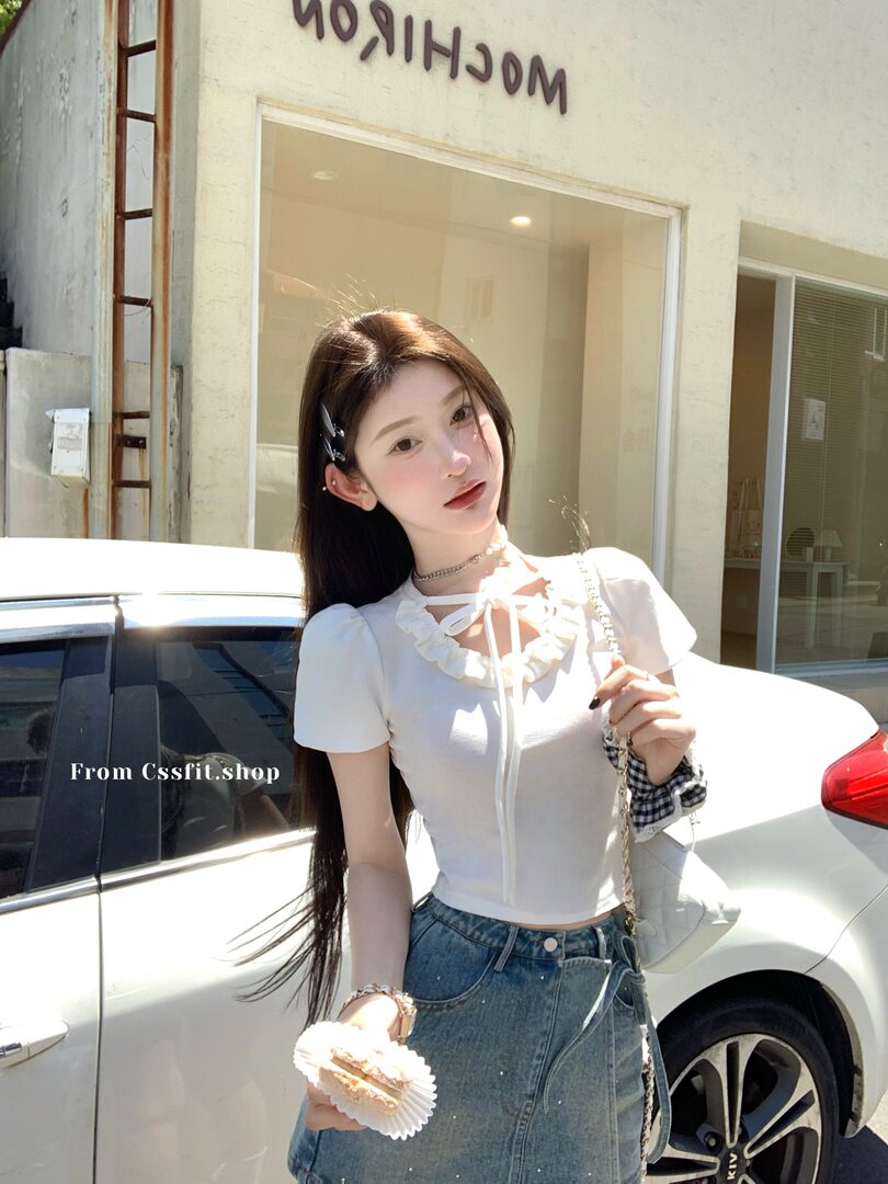 White short-sleeve ruffled crop top worn by a model with jeans
