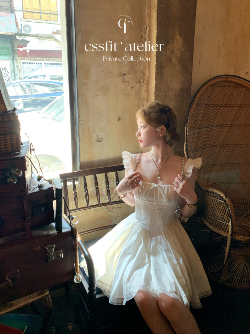 Woman wearing a white sleeveless dress in a vintage interior