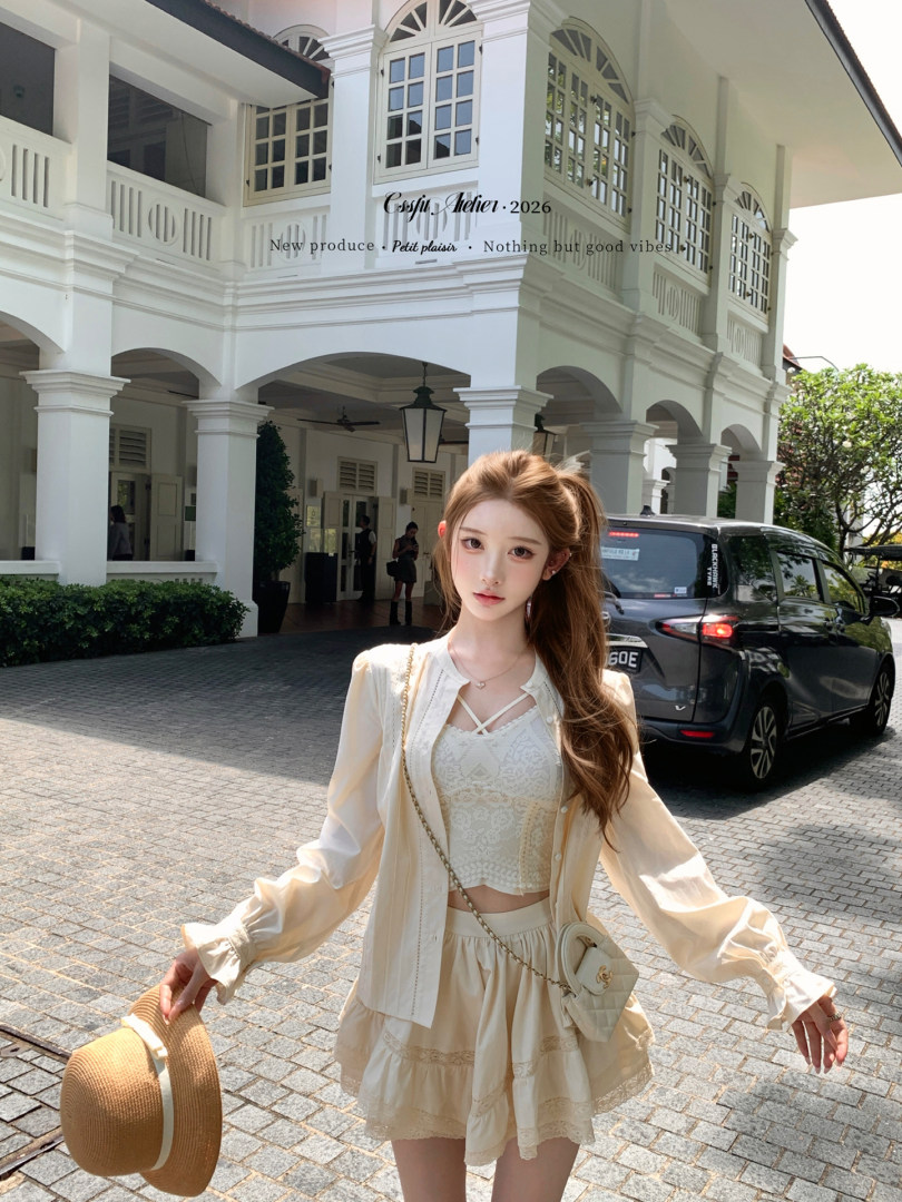 Model wearing a cream feminine two-piece outfit outdoors