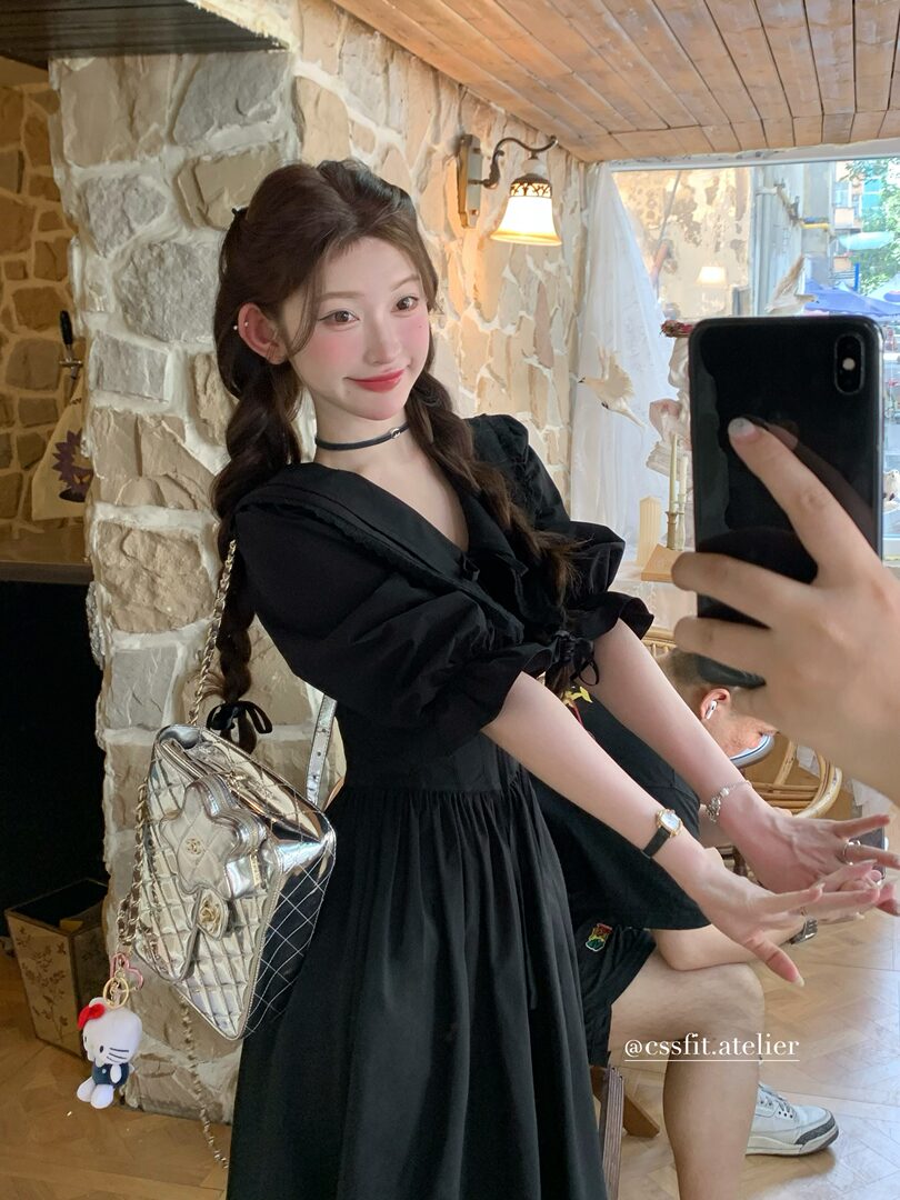 Black puff-sleeve dress worn by a woman in a mirror selfie