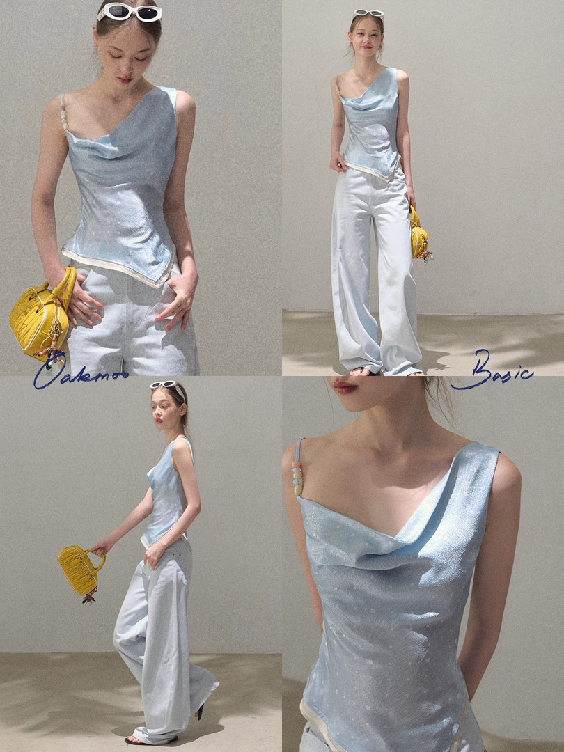 Model wearing a light blue asymmetrical satin camisole with white wide-leg pants