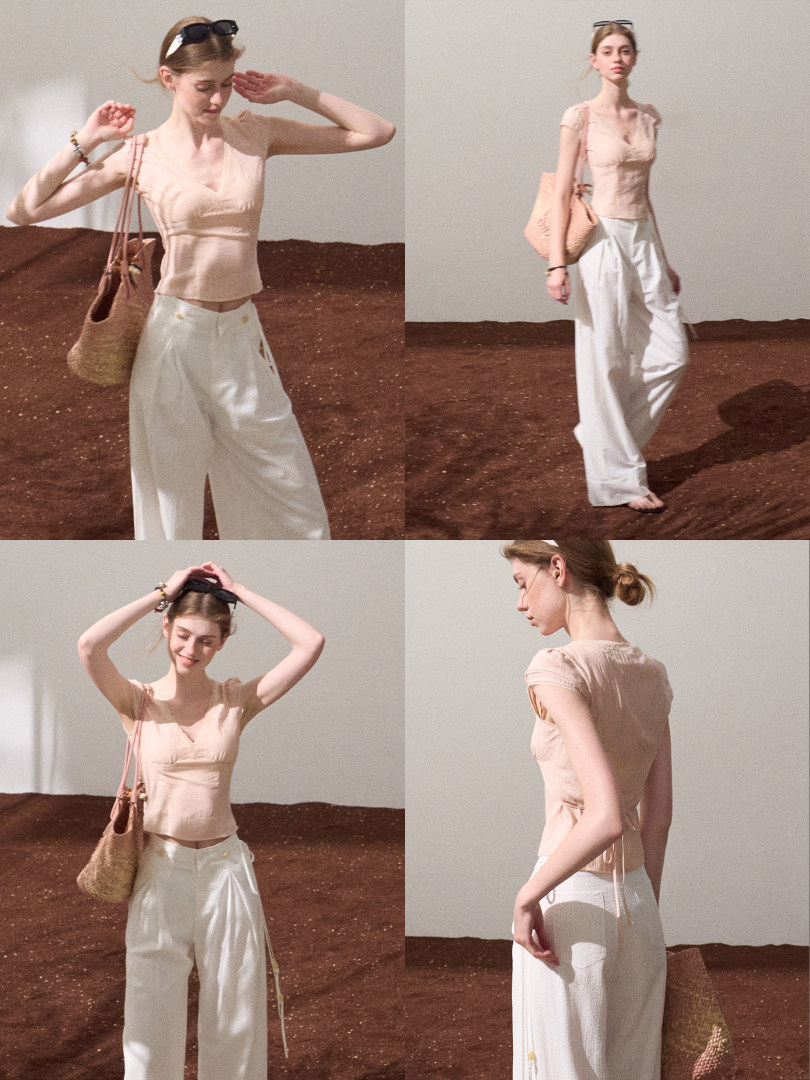 Model wearing a light peach sleeveless top with white wide-leg pants