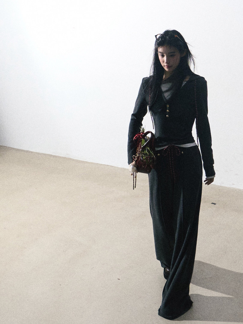 Black long-sleeve outfit with wide-leg pants worn by a model