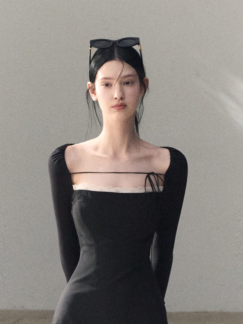 Model wearing a black fitted off-shoulder dress