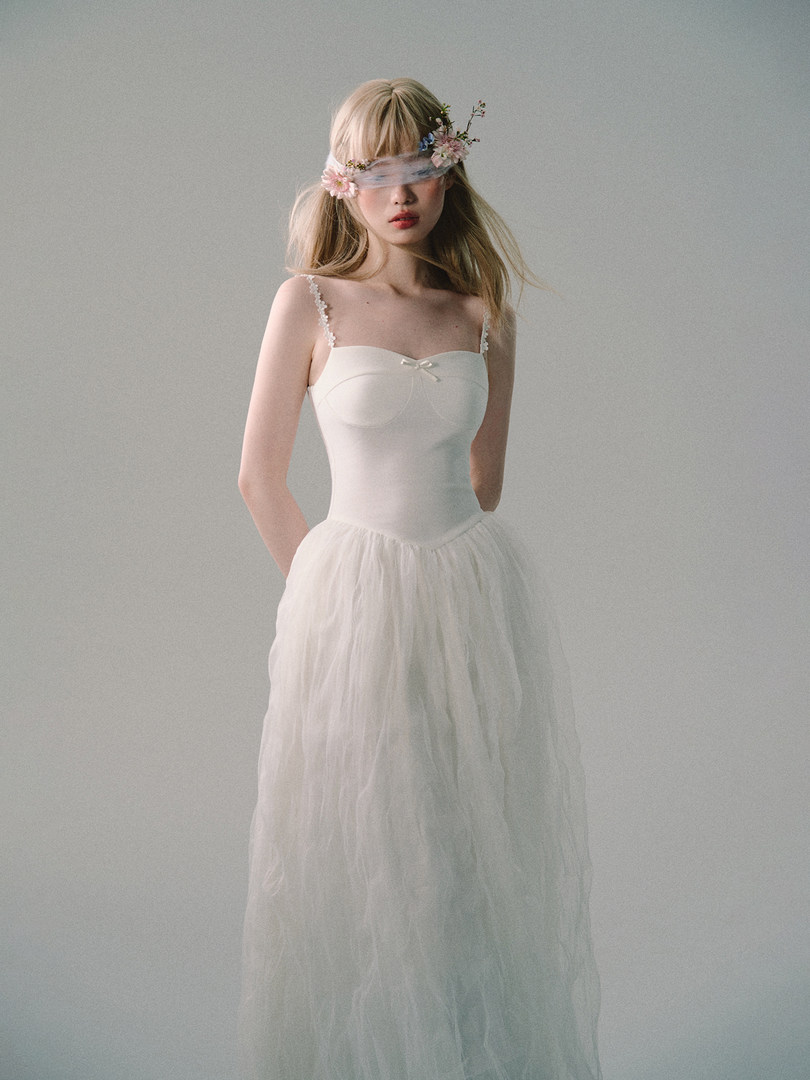 White sleeveless dress with sheer tulle skirt worn by a model