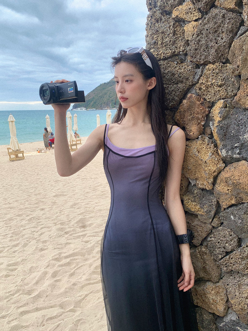 Woman wearing a purple layered dress on a beach