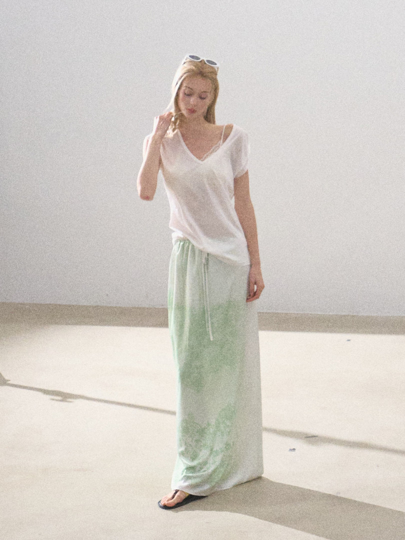 Woman wearing a sheer white top with mint green wide-leg pants