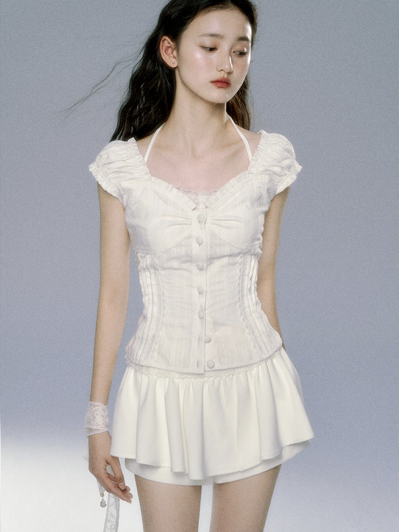 White ruffled corset-style top and matching skirt worn by a model