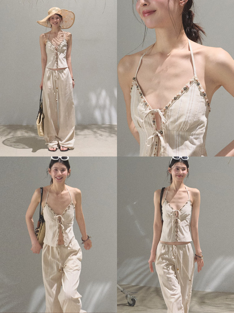 Model wearing a cream two-piece summer outfit with a lace-up camisole top and wide-leg pants