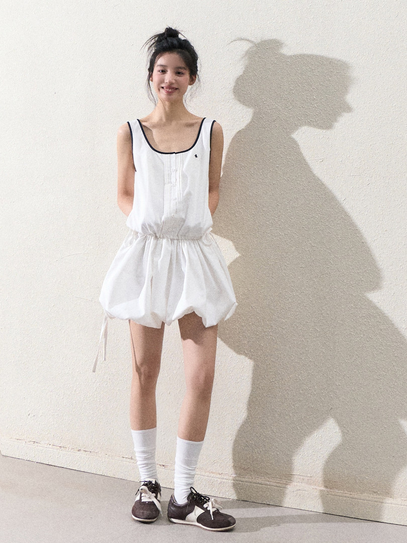 White sleeveless bubble romper worn by a model