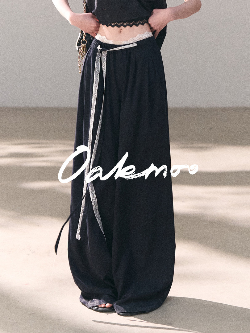 Model wearing black wide-leg pants with lace trim and a cropped top