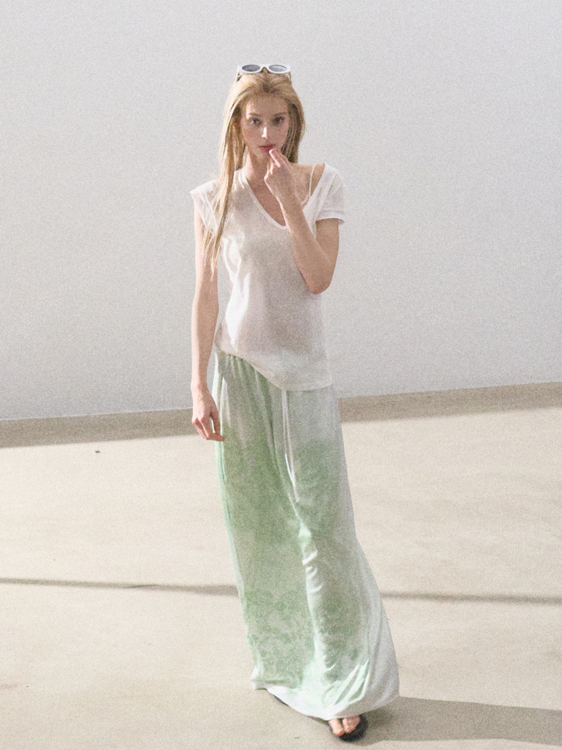 Model wearing a white V-neck T-shirt and light green wide-leg pants