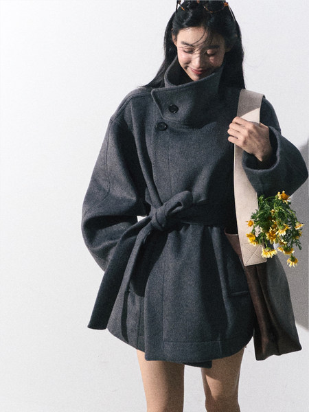 Dark gray belted wool coat worn by a model