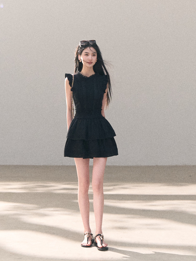 Black sleeveless ruffled mini dress worn by a model