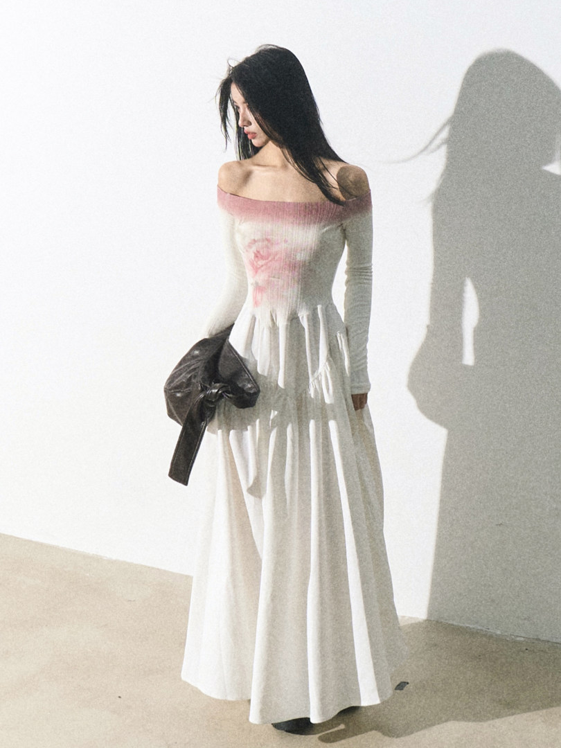 Model wearing a white off-shoulder long dress with pink gradient detail