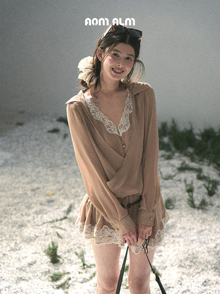 Woman wearing a beige lace-trimmed dress outdoors on a sandy beach