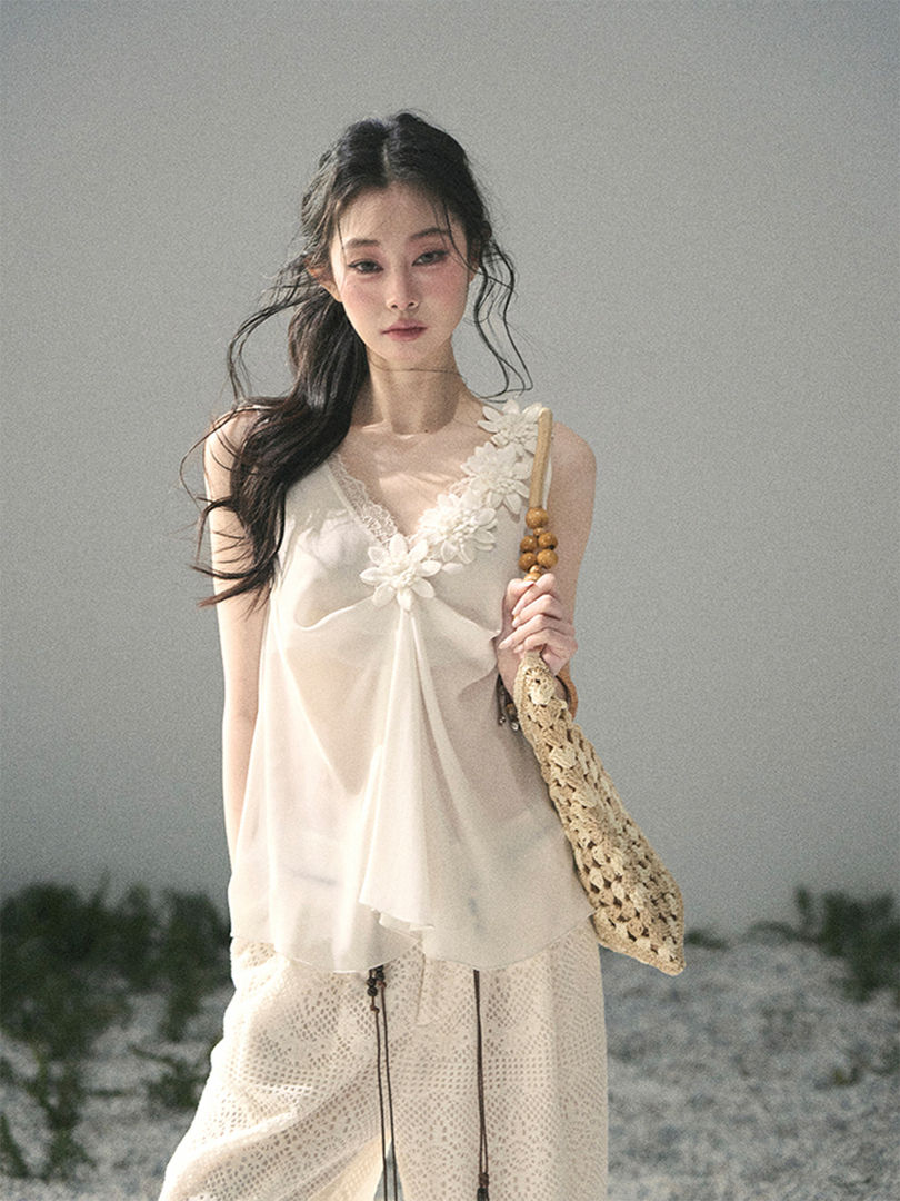 Model wearing a light cream floral-trim summer outfit with a woven bag