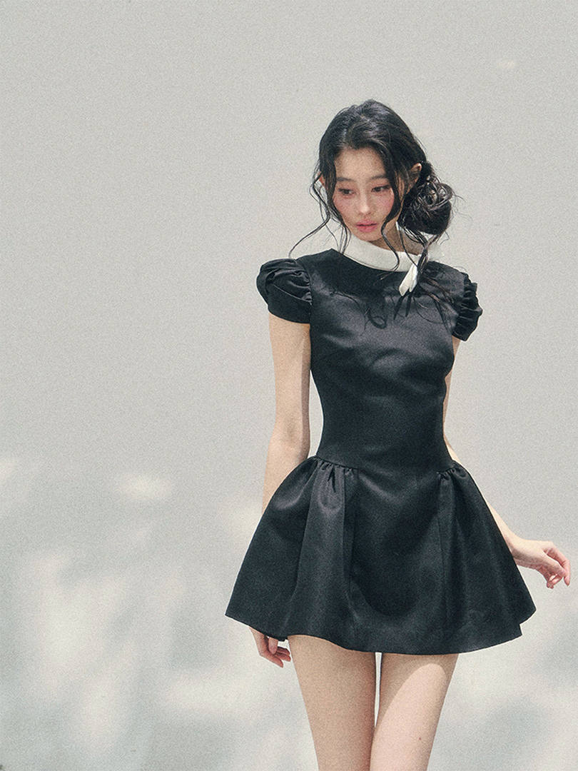 Black short puff-sleeve dress worn by a model