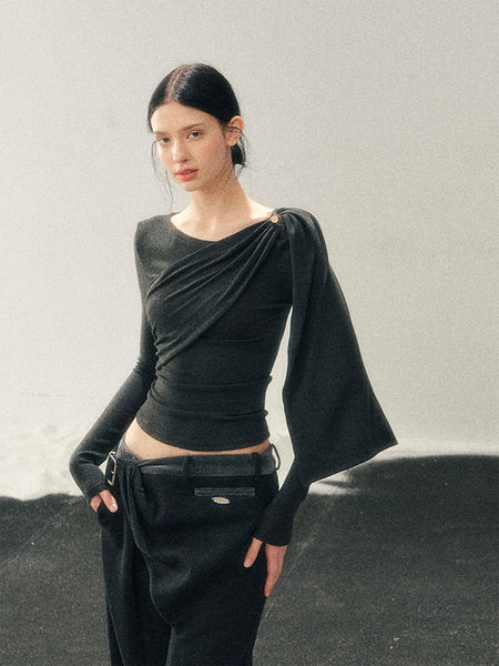 Model wearing a black draped long-sleeve top with matching black pants