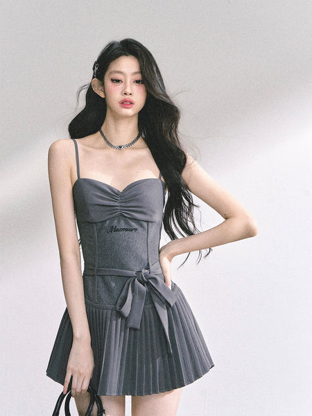 Gray sleeveless ruched dress with a pleated skirt worn by a model