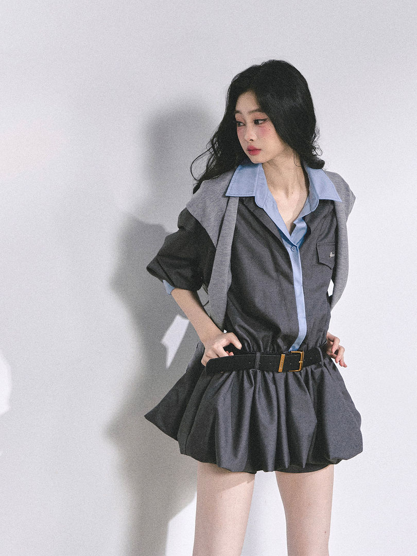 Model wearing a dark gray belted shirt dress with light blue collar and cuffs