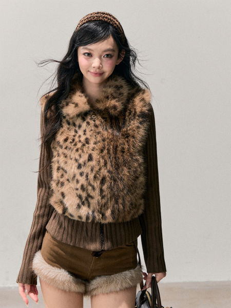Model wearing a leopard print faux fur vest with a brown knit top and fur-trim shorts