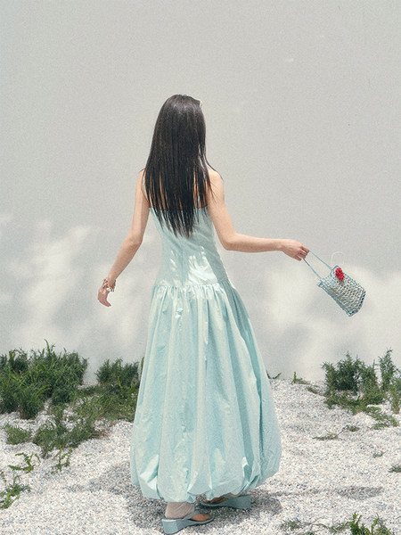 Woman wearing a light blue sleeveless maxi dress outdoors