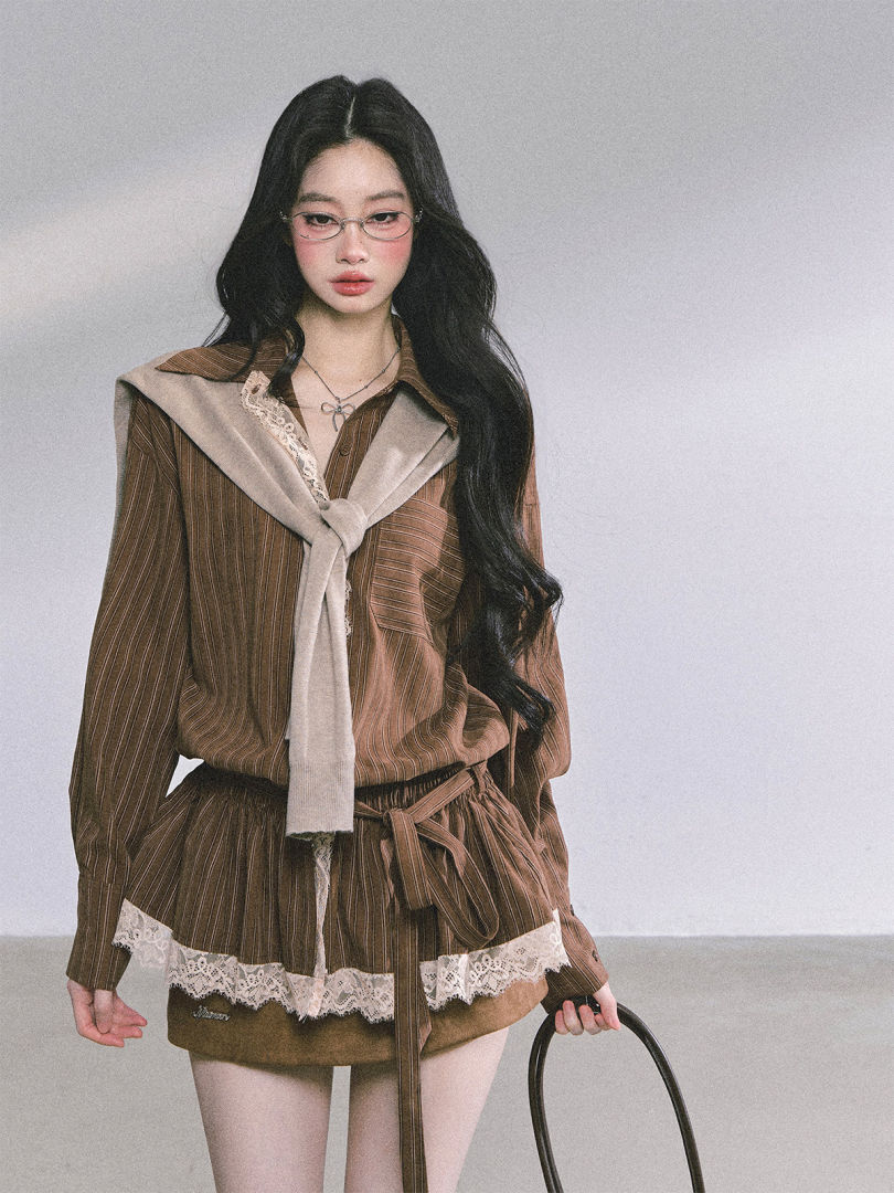 Model wearing a brown striped lace-trimmed outfit with a sweater draped over the shoulders