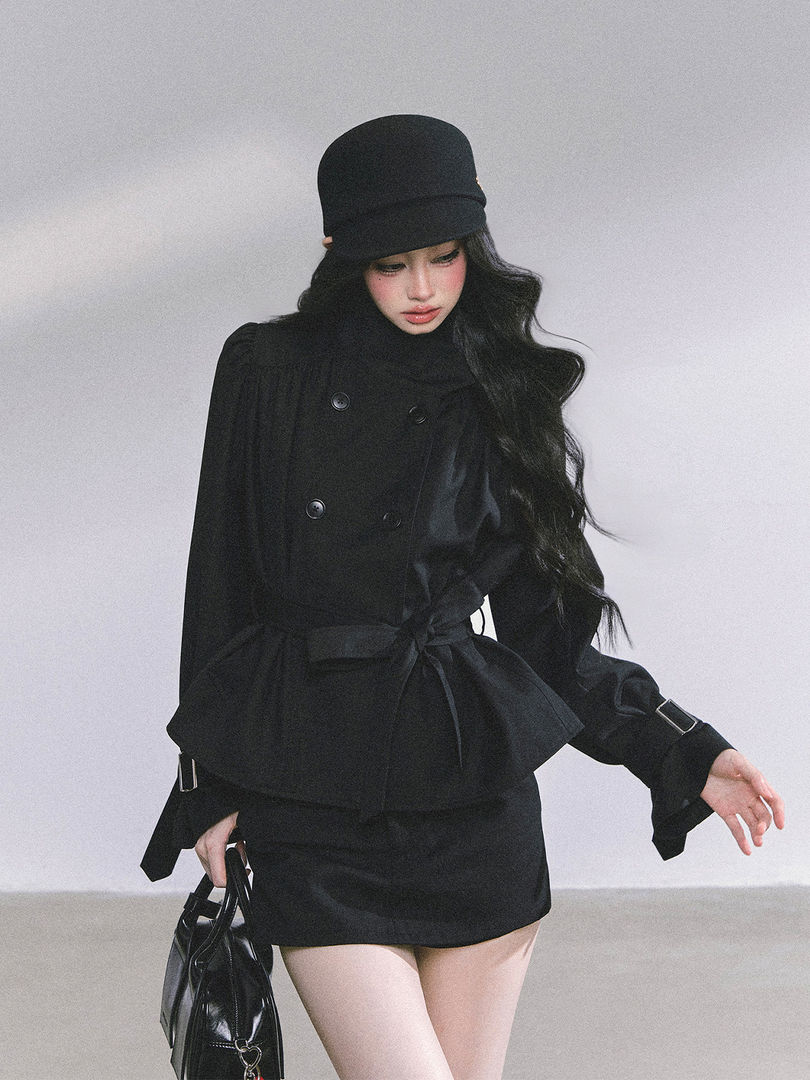 Black fashion outfit with coat, skirt, hat, and handbag on a model