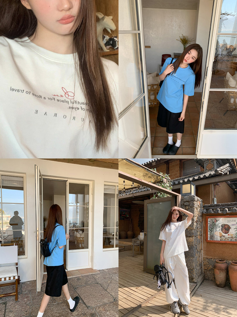 Model wearing oversized printed T-shirt in white and blue styled with casual pants