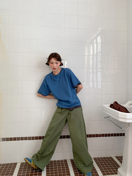 Model wearing a blue oversized T-shirt and green wide-leg pants