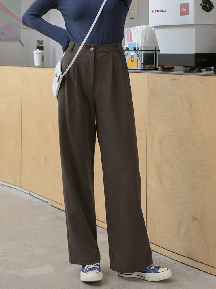 Brown wide-leg trousers worn with a blue top and sneakers