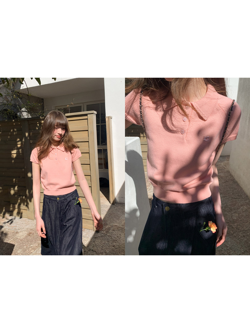 Model wearing a pink short-sleeve polo knit top with a dark denim skirt