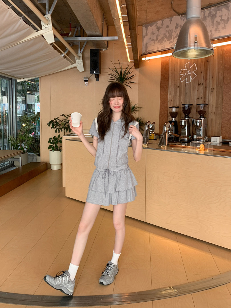 Woman wearing a gray short-sleeve dress with tiered skirt in a cafe