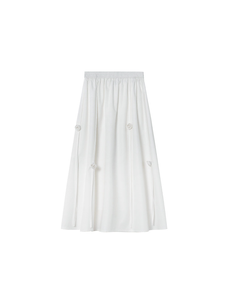 White midi skirt with a gathered waistband and small floral details on a plain background