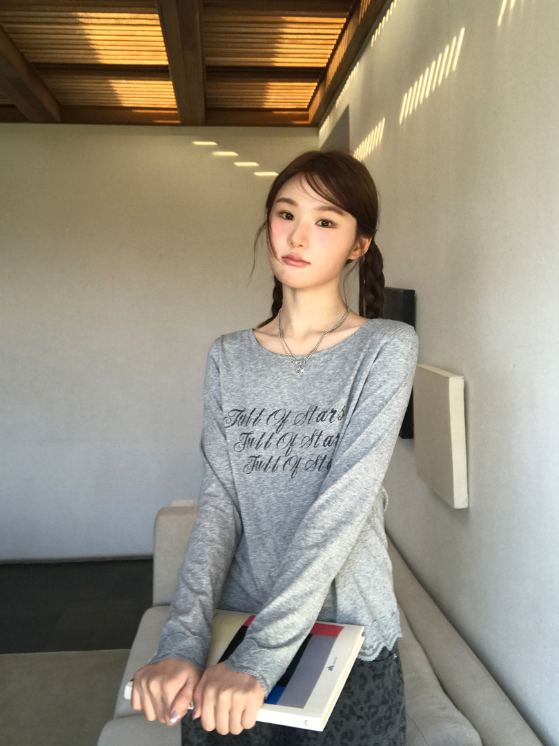 Model wearing a gray long-sleeve printed top
