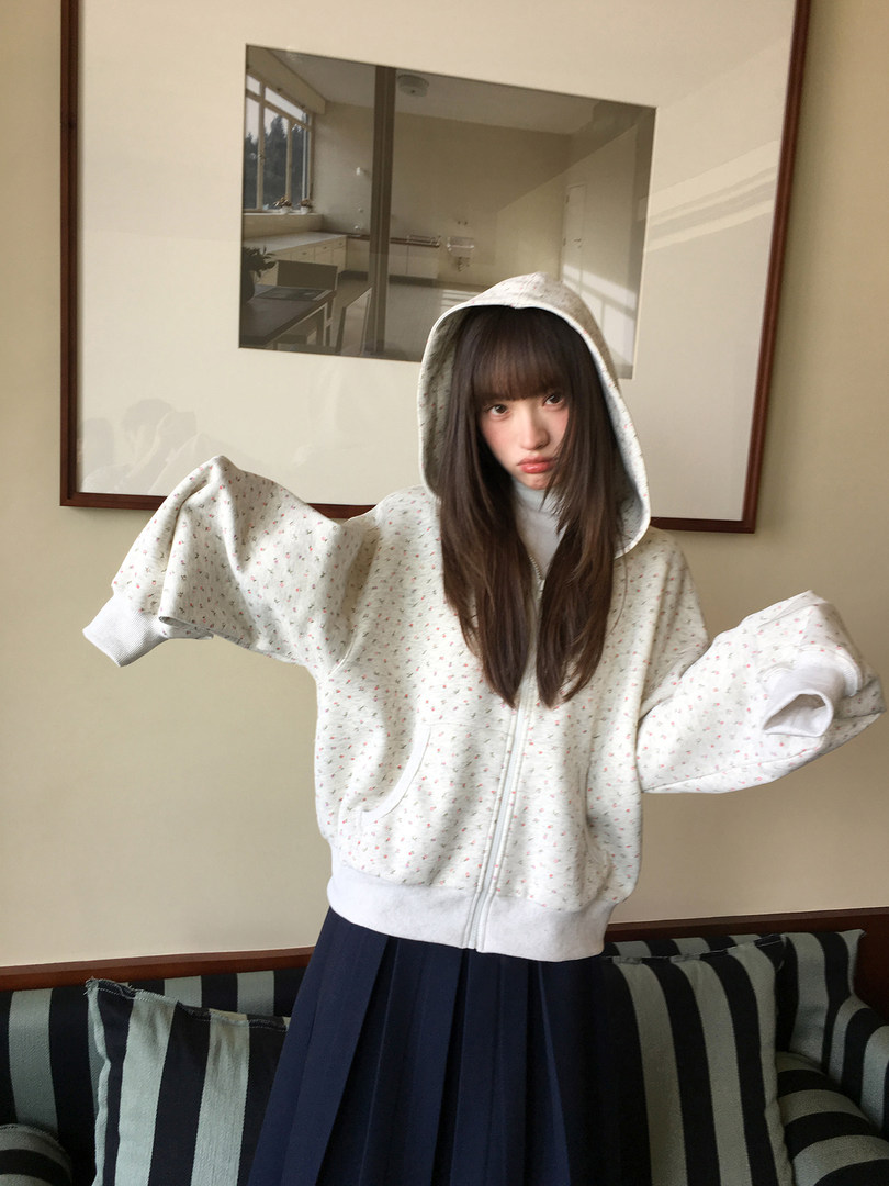 Model wearing a light patterned zip-up hoodie with a hood