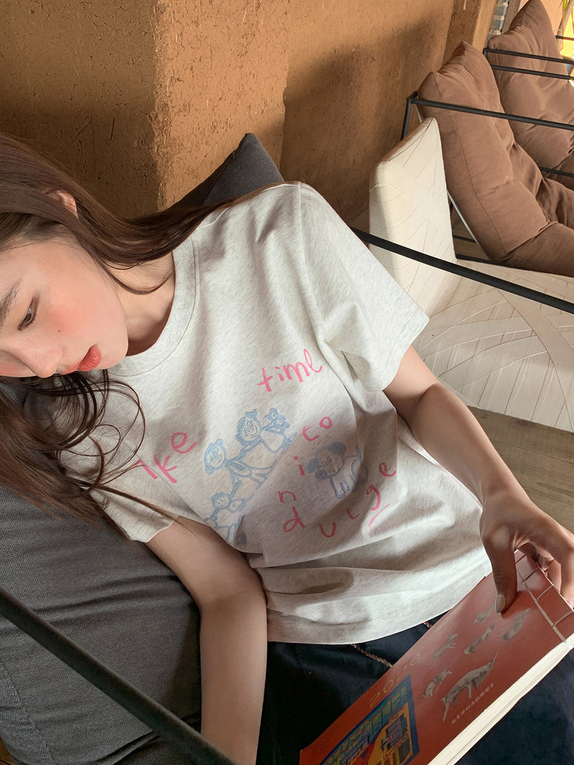 Model wearing a light-colored graphic T-shirt with pink and blue print