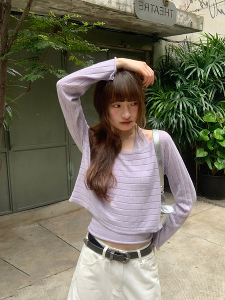 Woman wearing a lavender ribbed long-sleeve top with white pants outdoors