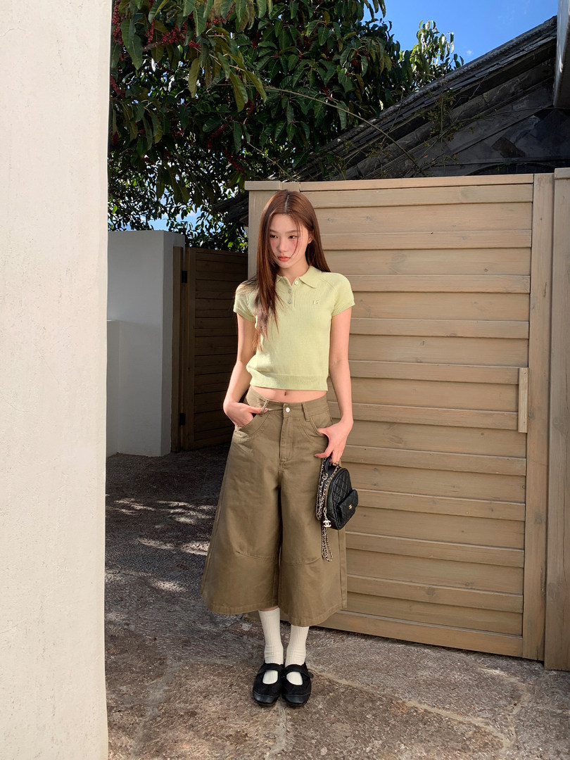 Model wearing a light green cropped polo top with wide-leg khaki pants