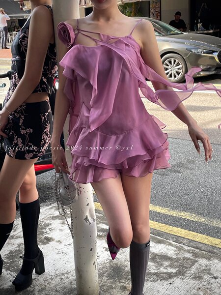Woman wearing a pink ruffled mini dress with sheer flowing details