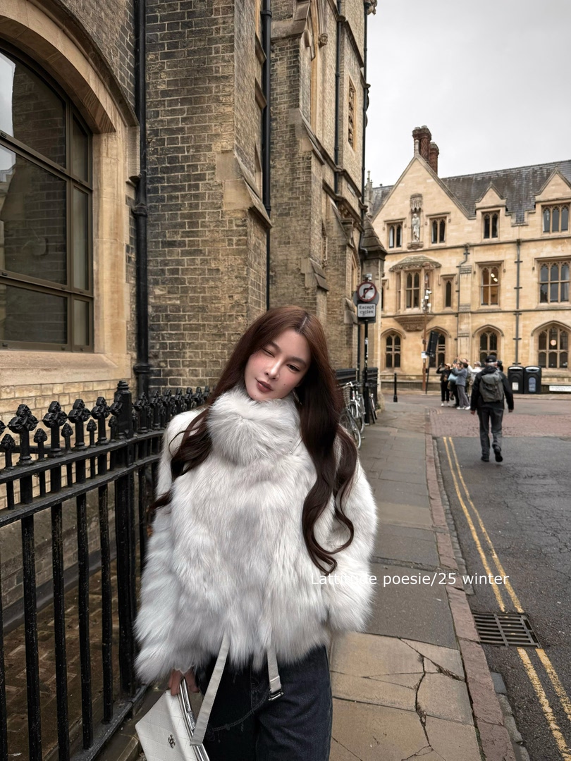 Woman wearing a white faux fur coat on a city street