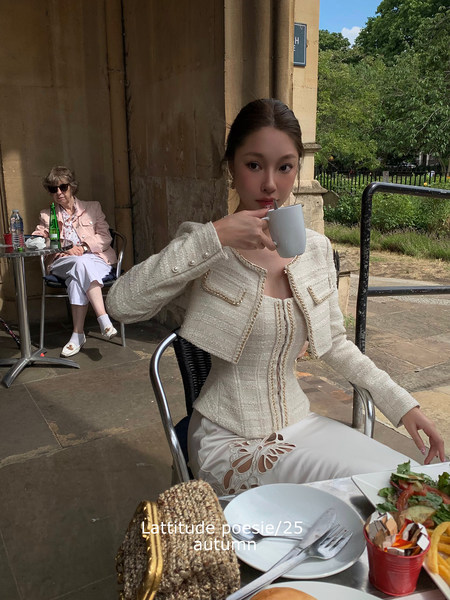 Woman wearing a cream tweed jacket and dress at an outdoor café